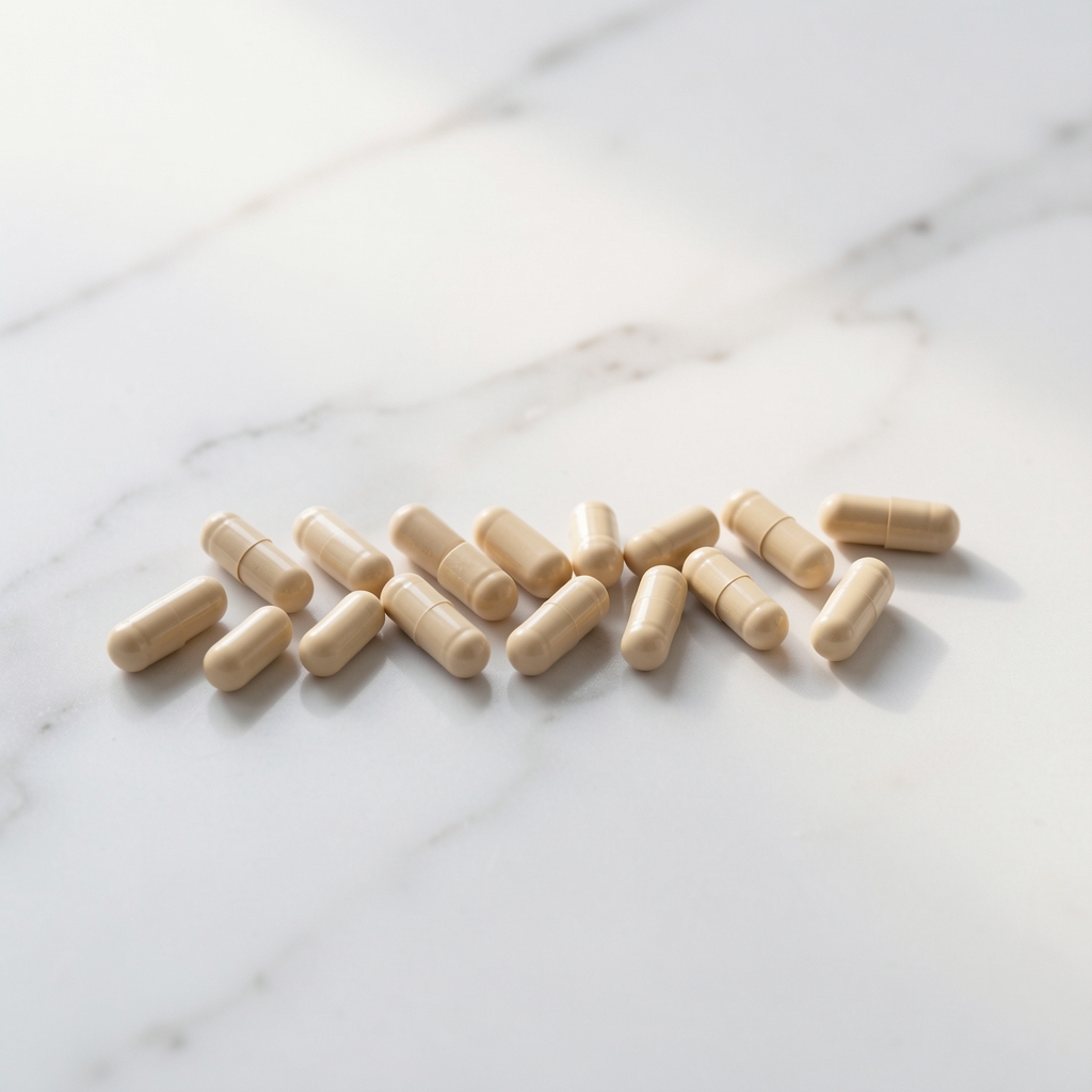 Daily supplement capsules arranged in a clean row on a white marble surface with soft ambient light